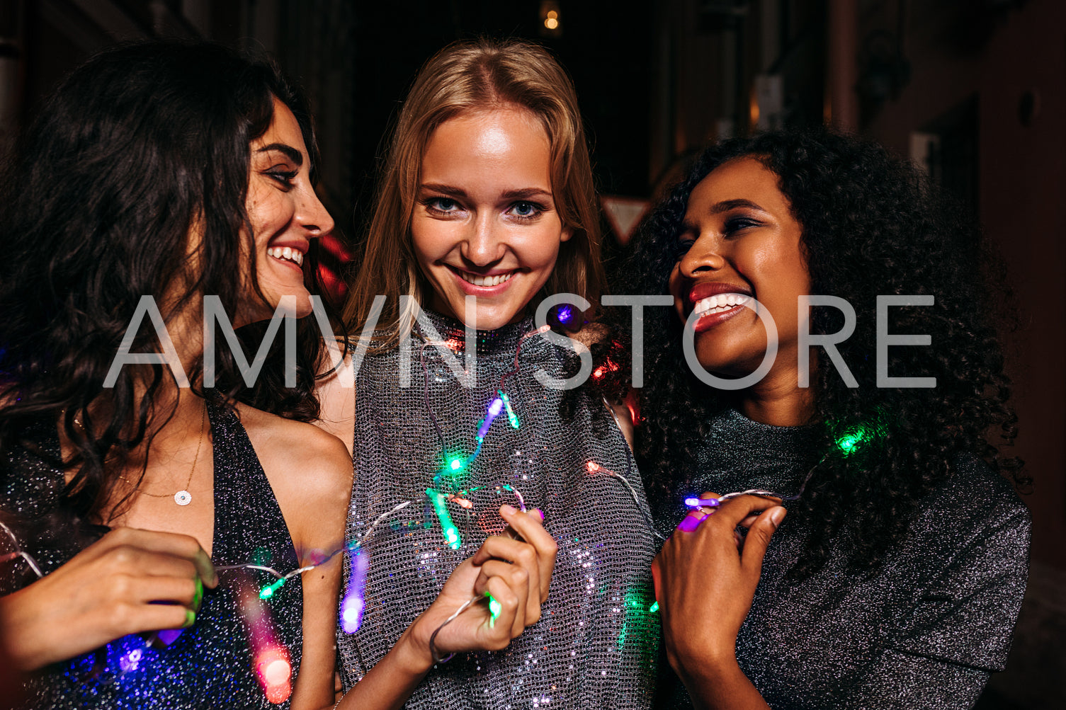 Three beautiful women celebrating new year, standing on street