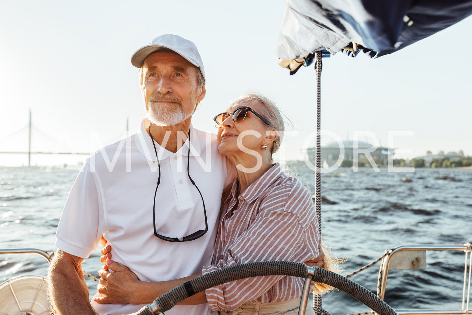 Elderly couple embracing on a private yacht while on vacation	