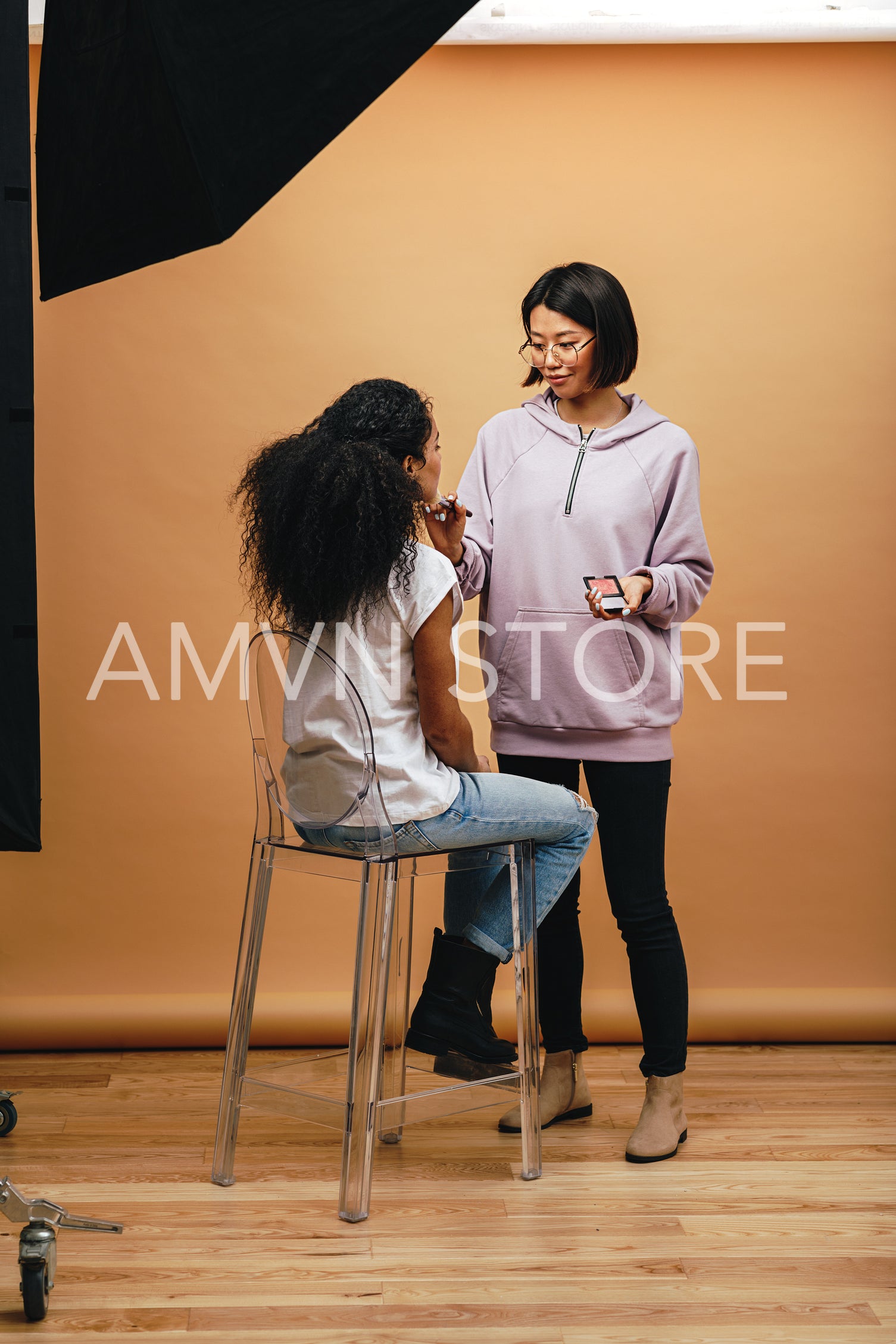 Makeup artist doing makeup to a model during photo shoot	
