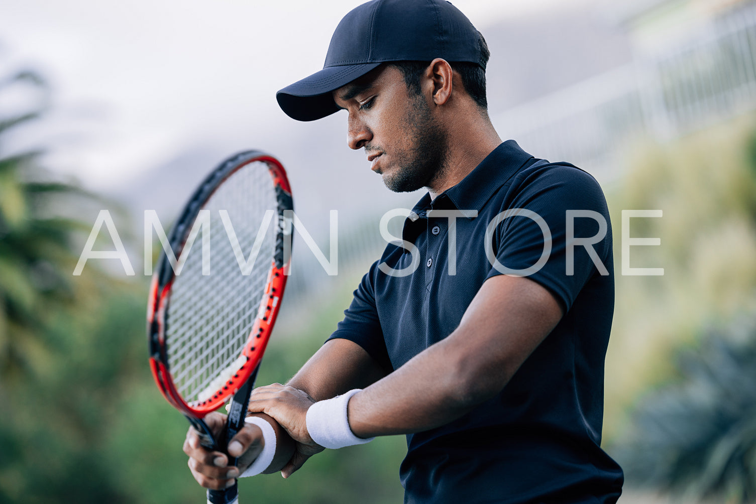 Professional tennis player touching his arm during training