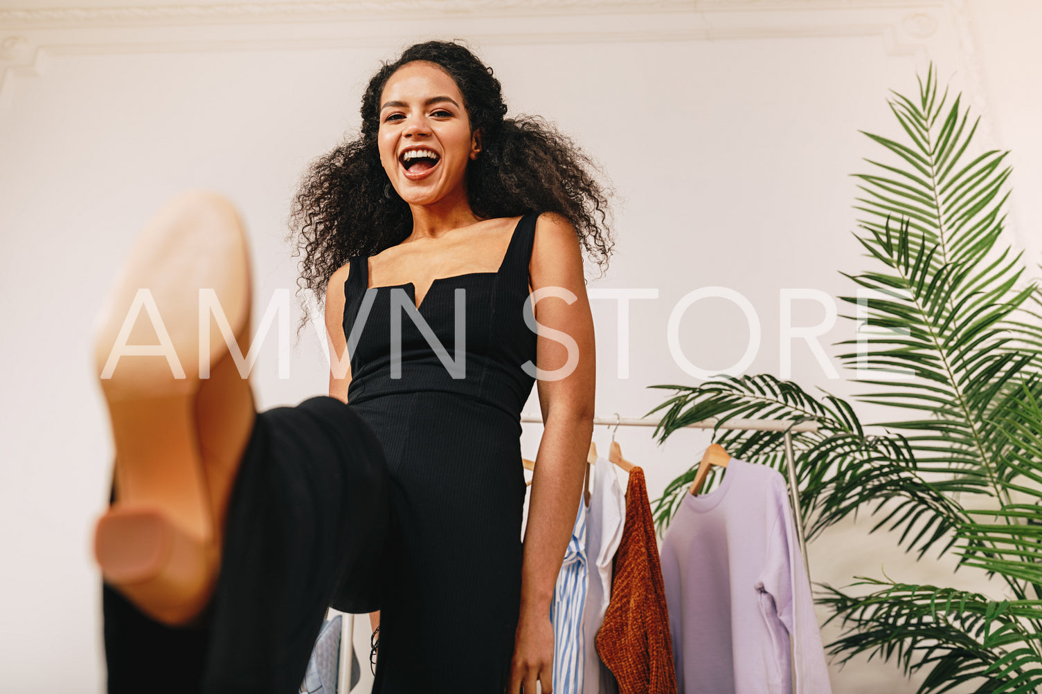 Happy personal stylist kicking a camera in studio	