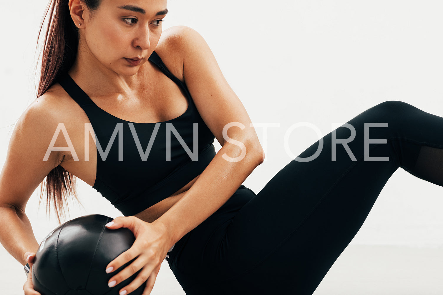 Close up of young Asian woman exercising with medicine ball indoors