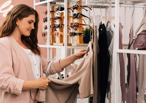 Side view of a smiling plus size woman shopping in a small cloth