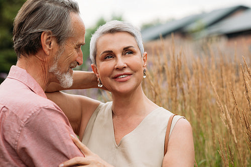 Two senior people standing together in the field outdoors