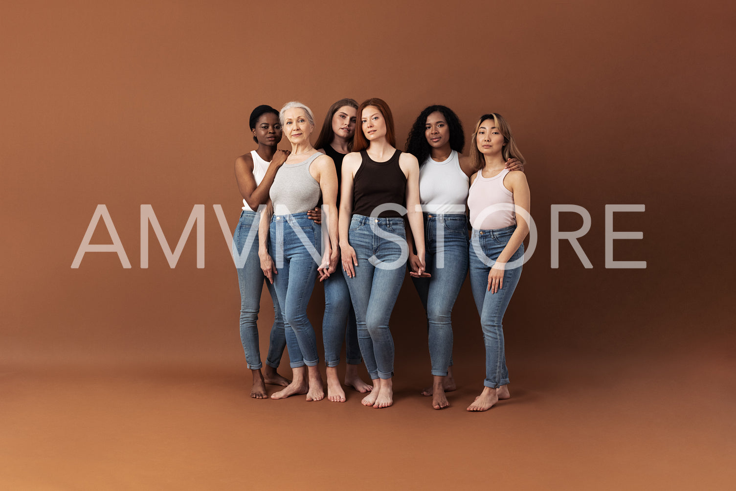 Six women of different ages standing together in studio. Females holding hands and looking at camera.