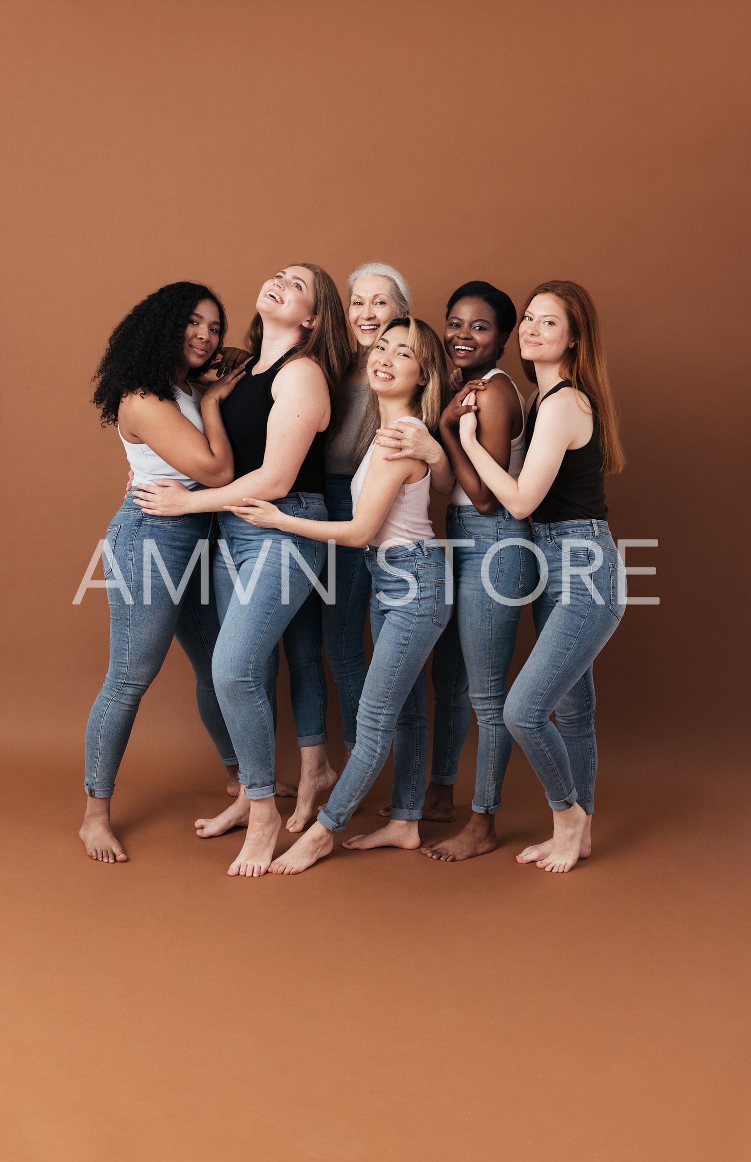 Group of cheerful women of different body type and ages standing together in a studio