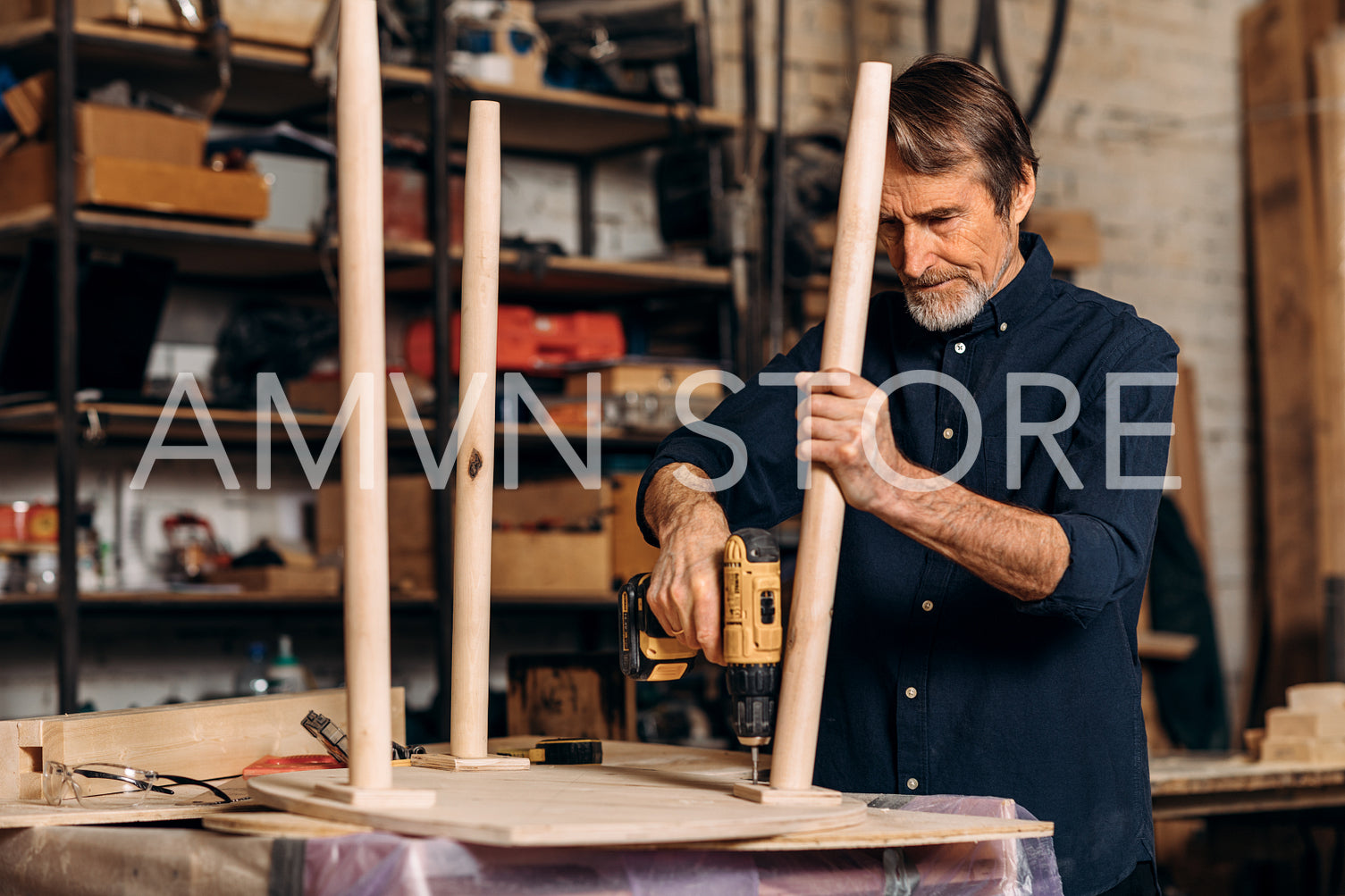 Senior carpenter repairing a table in his workshop	