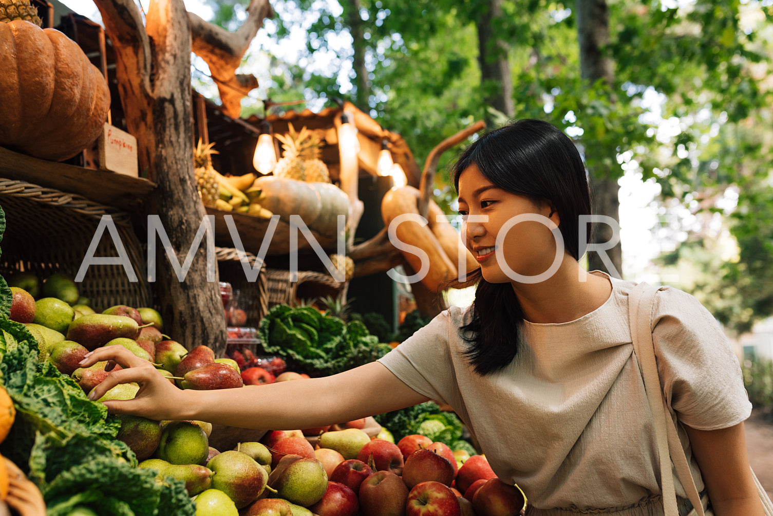 Woman at a farmers market with organic fruits and vegetables. Asian woman at a local outdoor market.