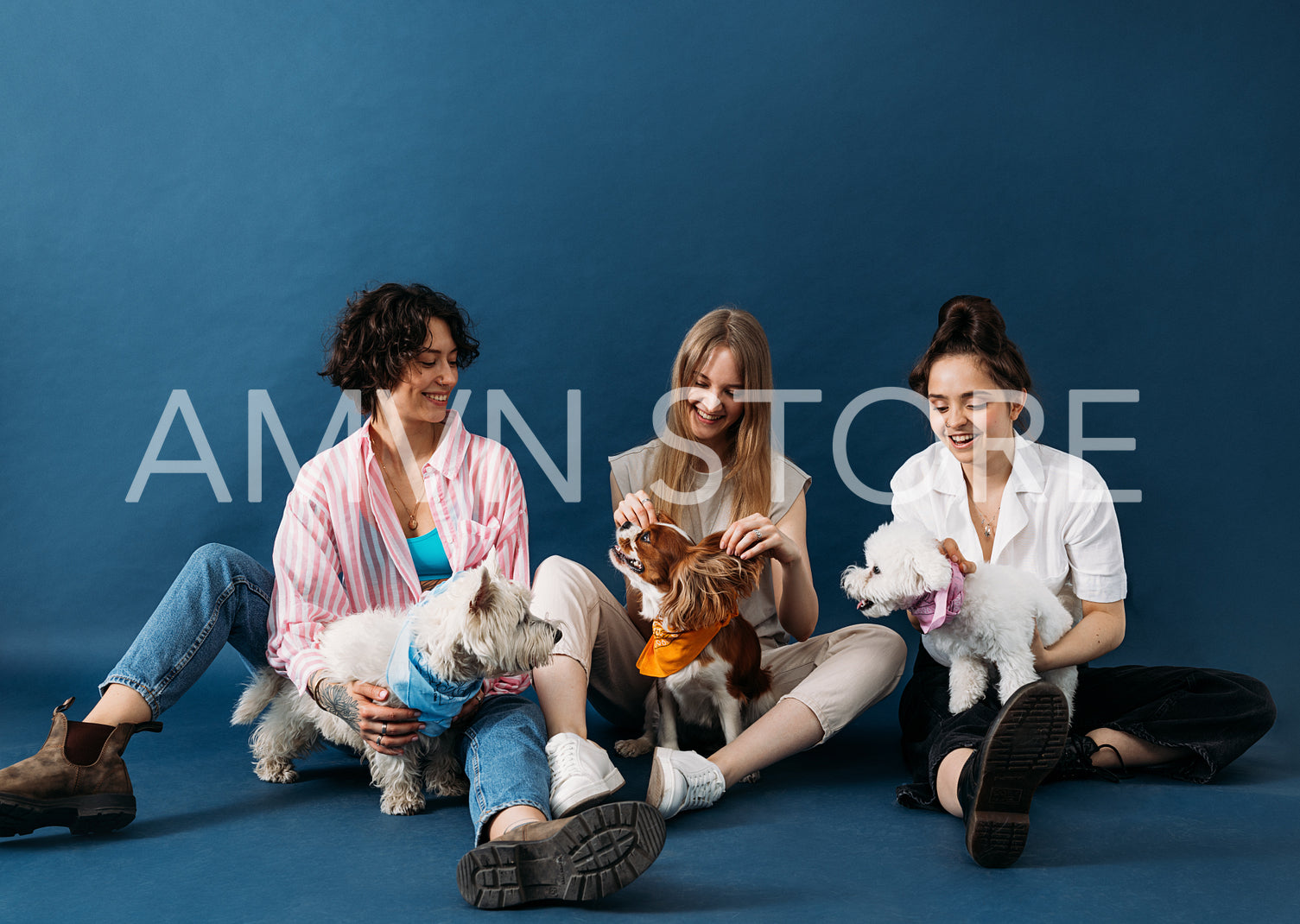 Three happy women sitting on a blue background with their cute d