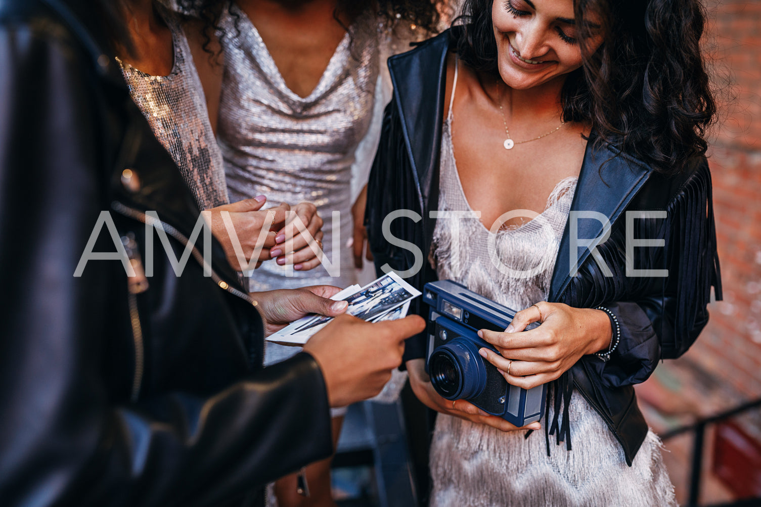 Hands of women with photographs and instant camera	