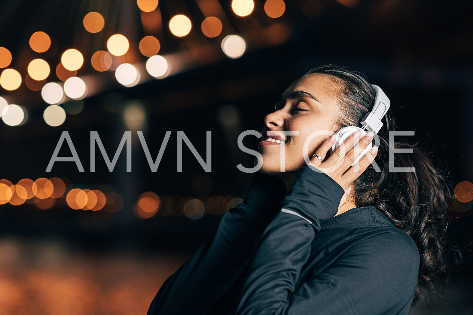 Woman in sports clothes with headphones enjoying music during training