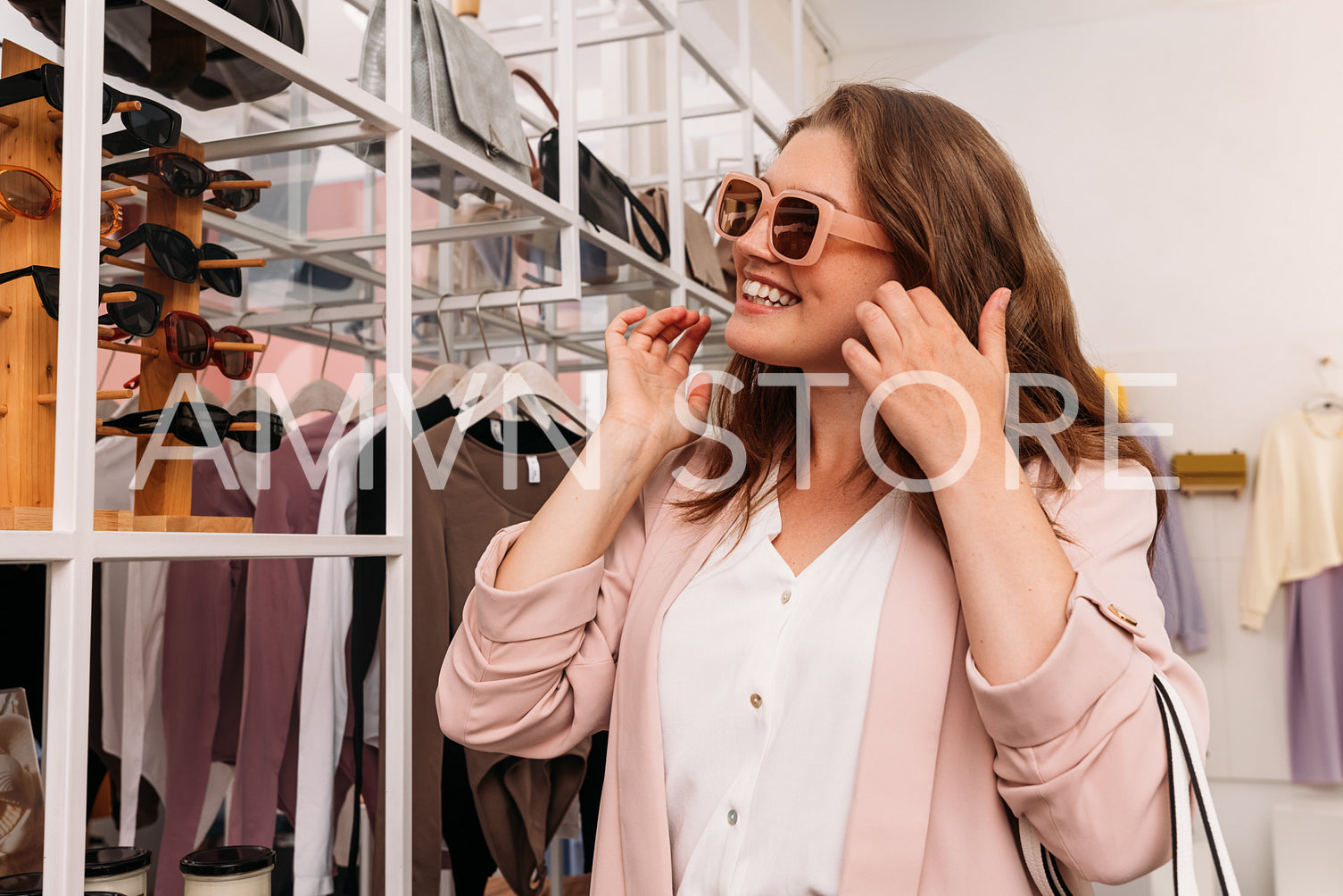 Smiling stylish woman wearing sunglasses in a fashion store