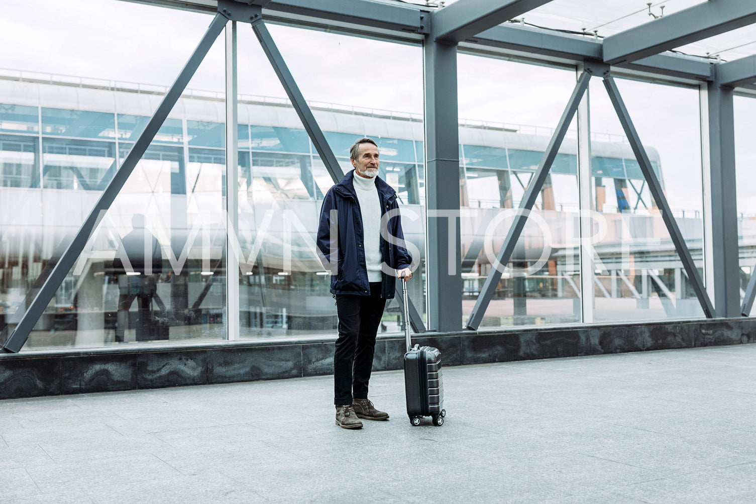 Man with suitcase standing in terminal. Aged tourist with baggage.	