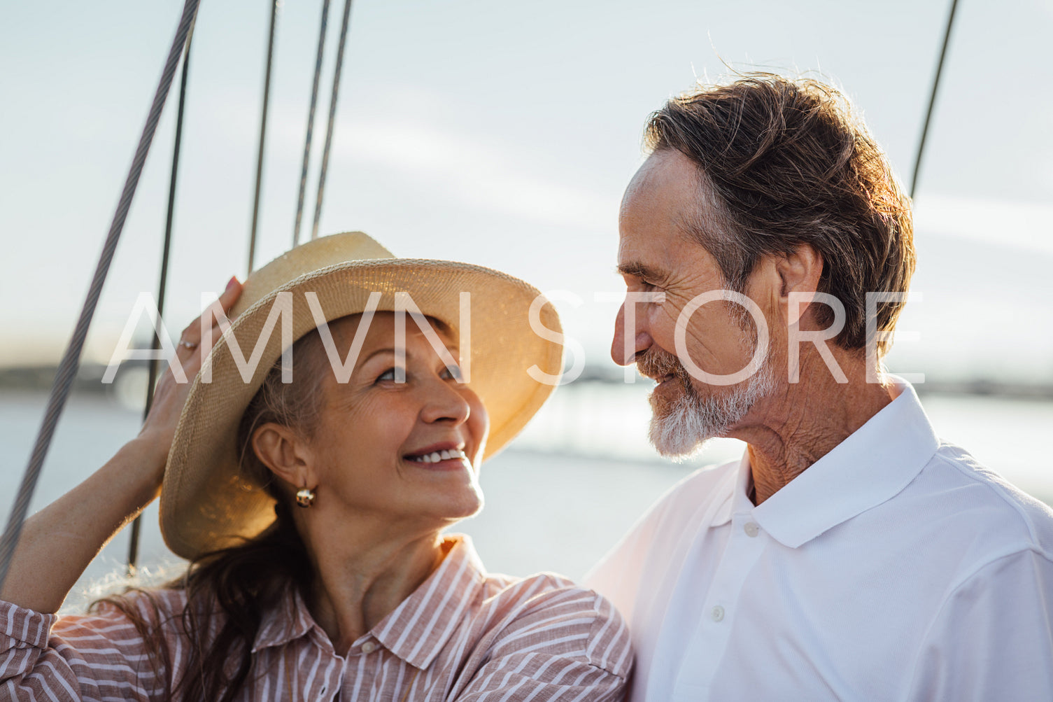 Affectionate couple on a boat trip looking to each other at sunset	