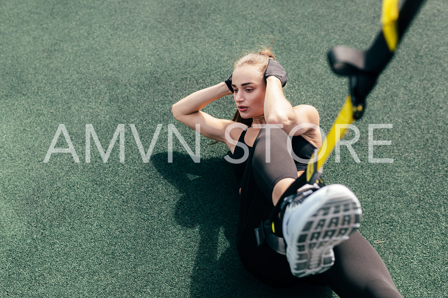 High angle view of woman athlete doing abdominal exercises using suspension straps	
