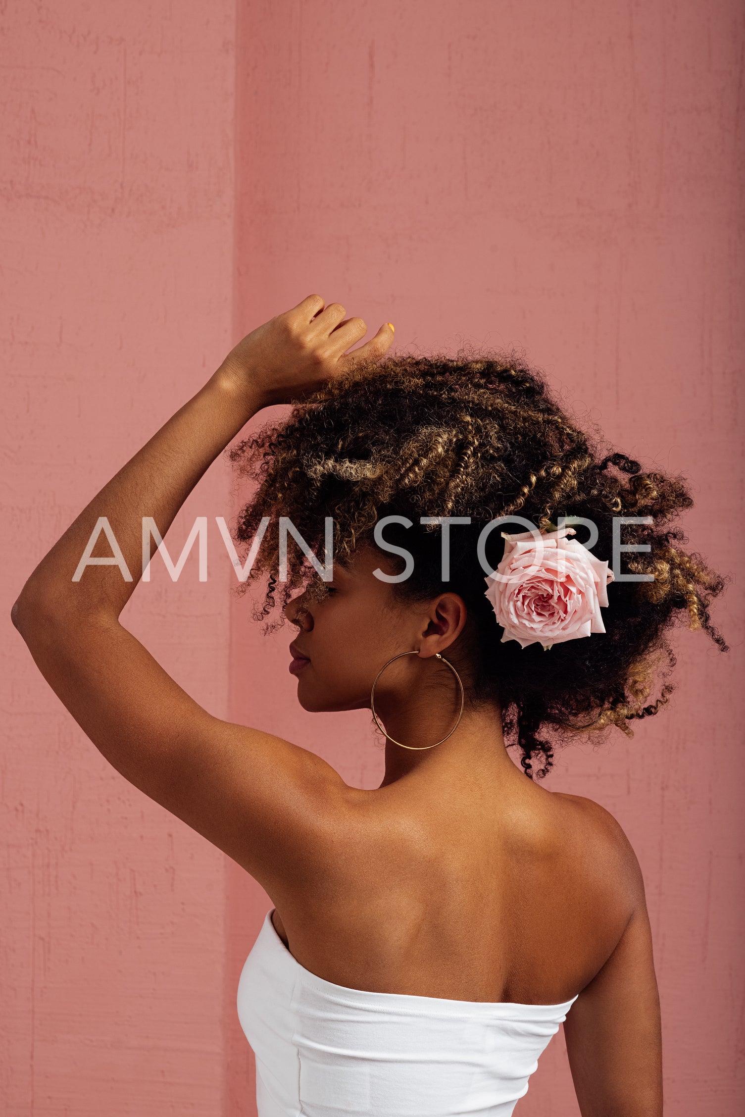 Woman with flower in her hair posing in a studio