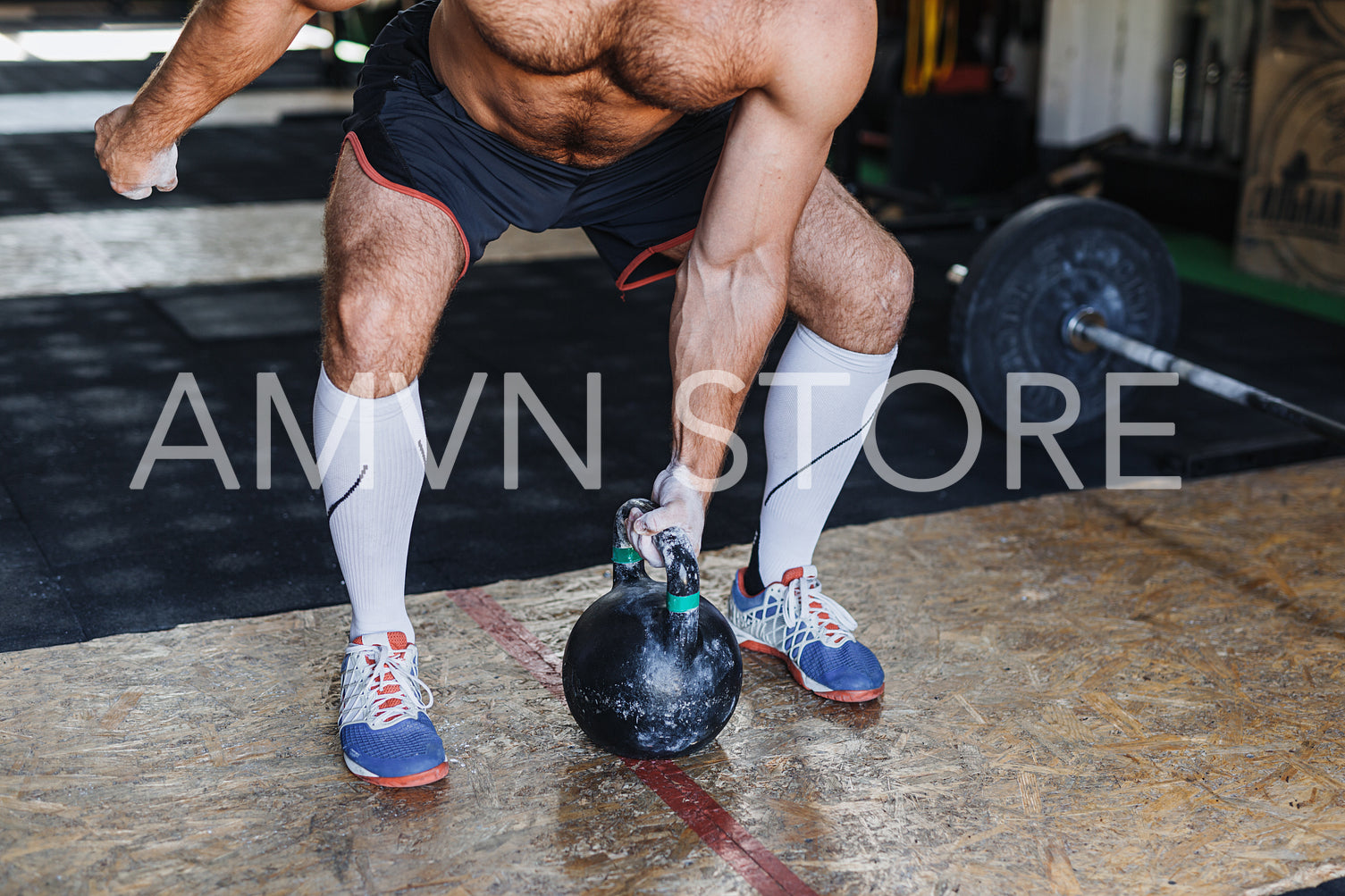 Unrecognizable fitness man working out with kettlebell in gym	