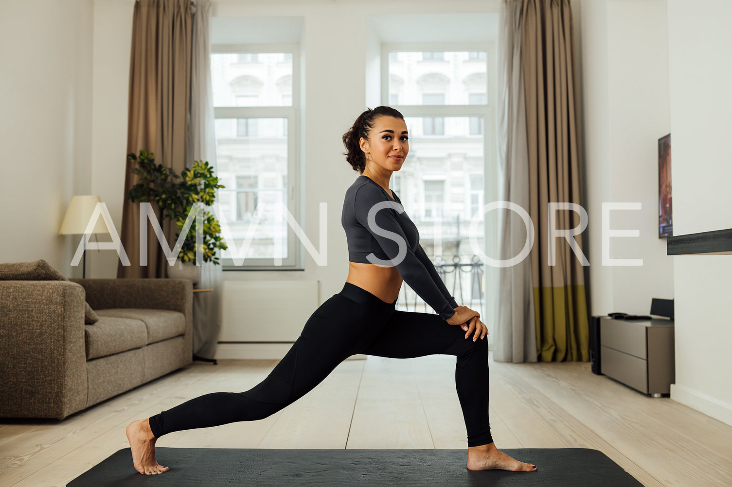 Smiling woman stretching her legs on a mat