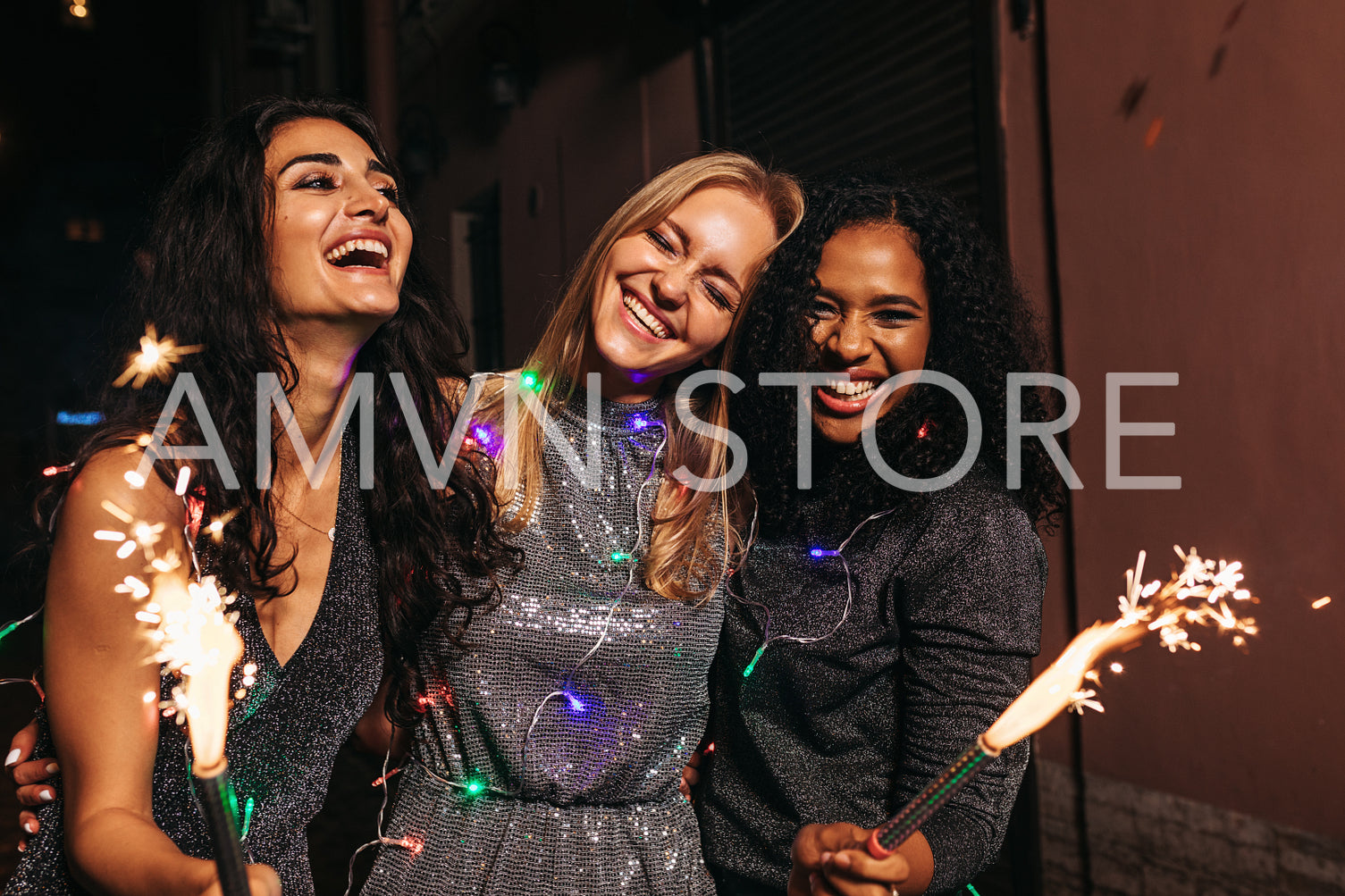 Happy friends celebrating new year with sparklers at night. Smiling women walking together.	