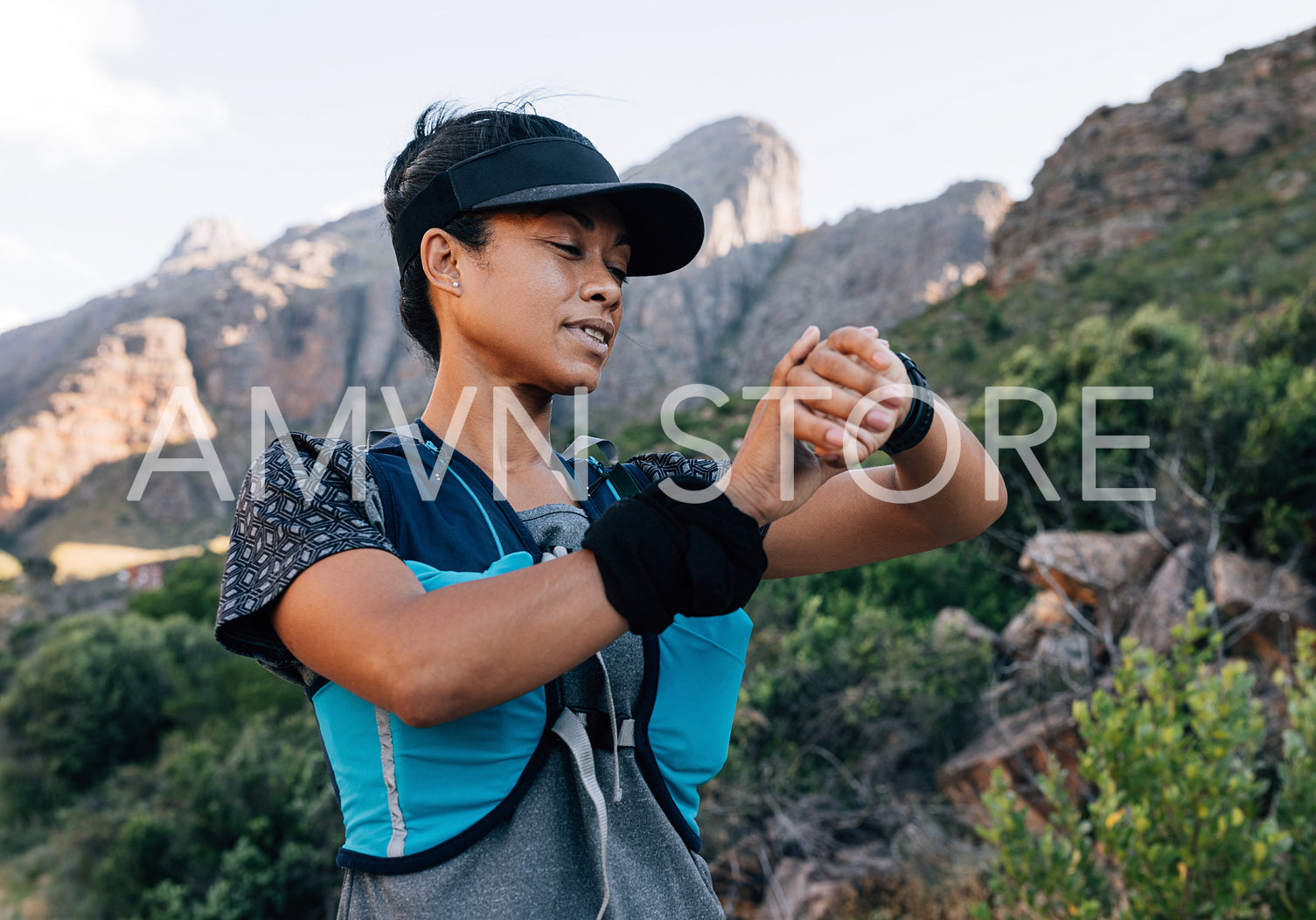 Woman hiker in cap looking at smart watch