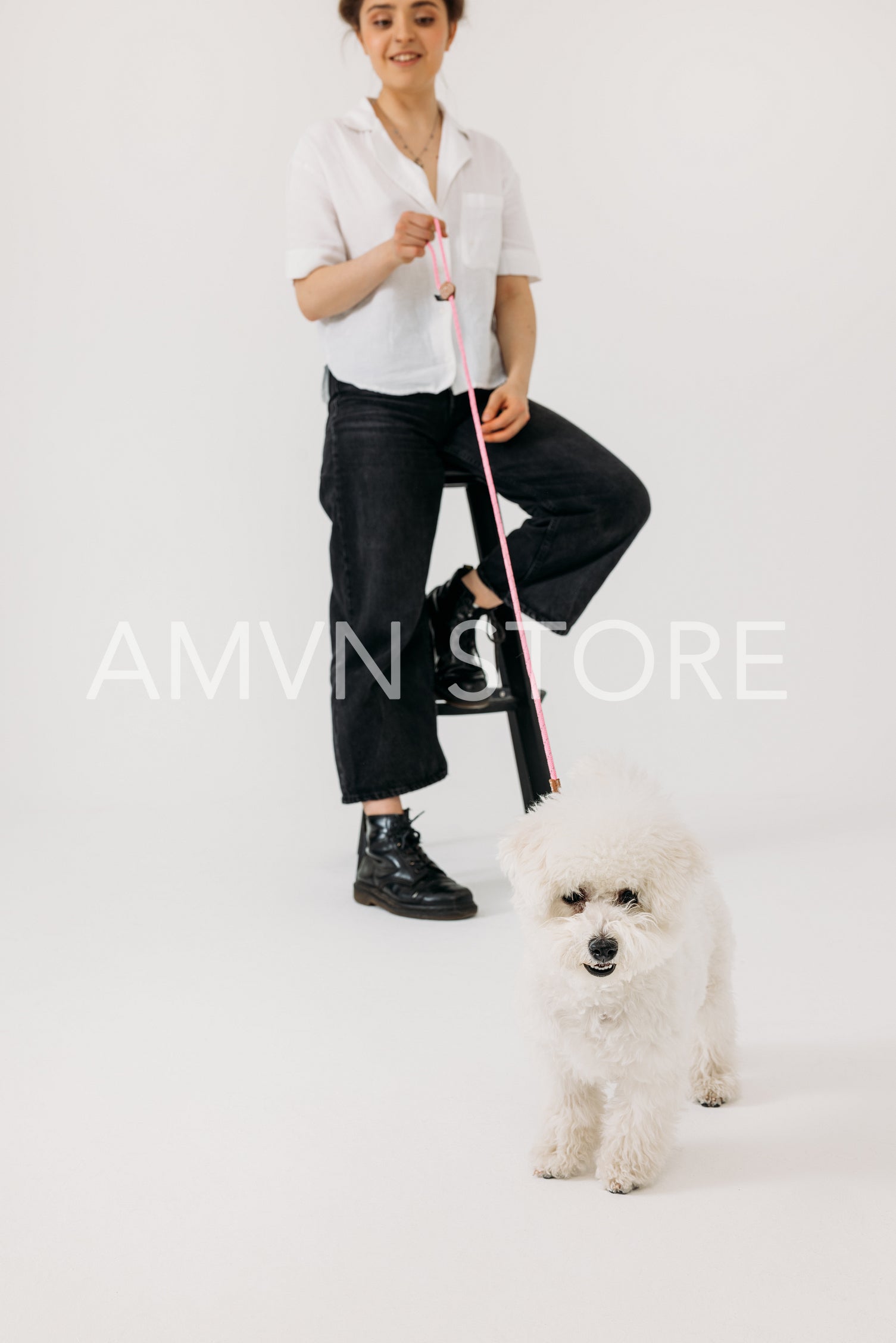 Young female with her fluffy dog against white background