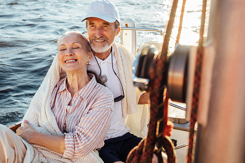 Happy mature couple enjoying their vacation on a sailboat