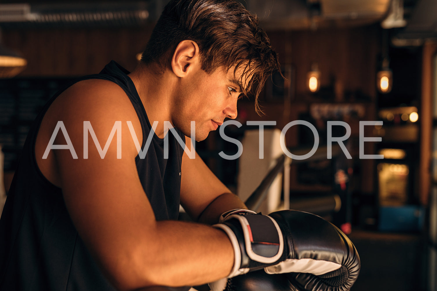 Side view of a tired and exhausted boxer standing in gym