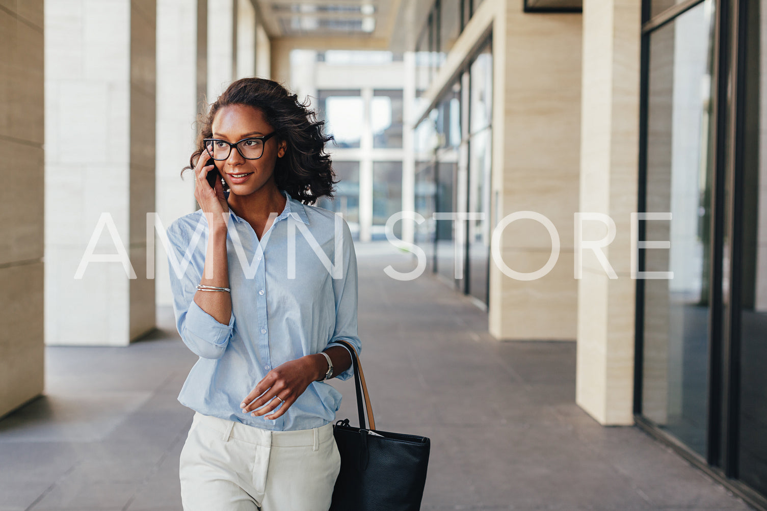 Woman in formalwear walking outdoors and using mobile phone	