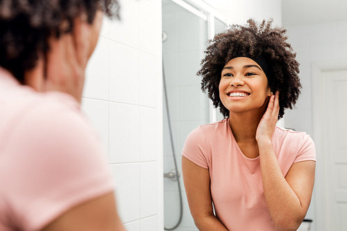 Smiling girl with hair bandage looking at mirror