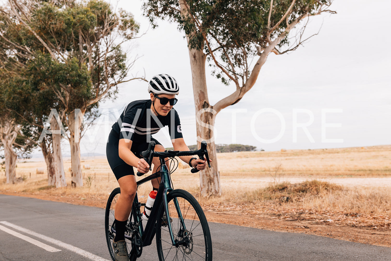 Female cyclist riding her pro bike fast on country road