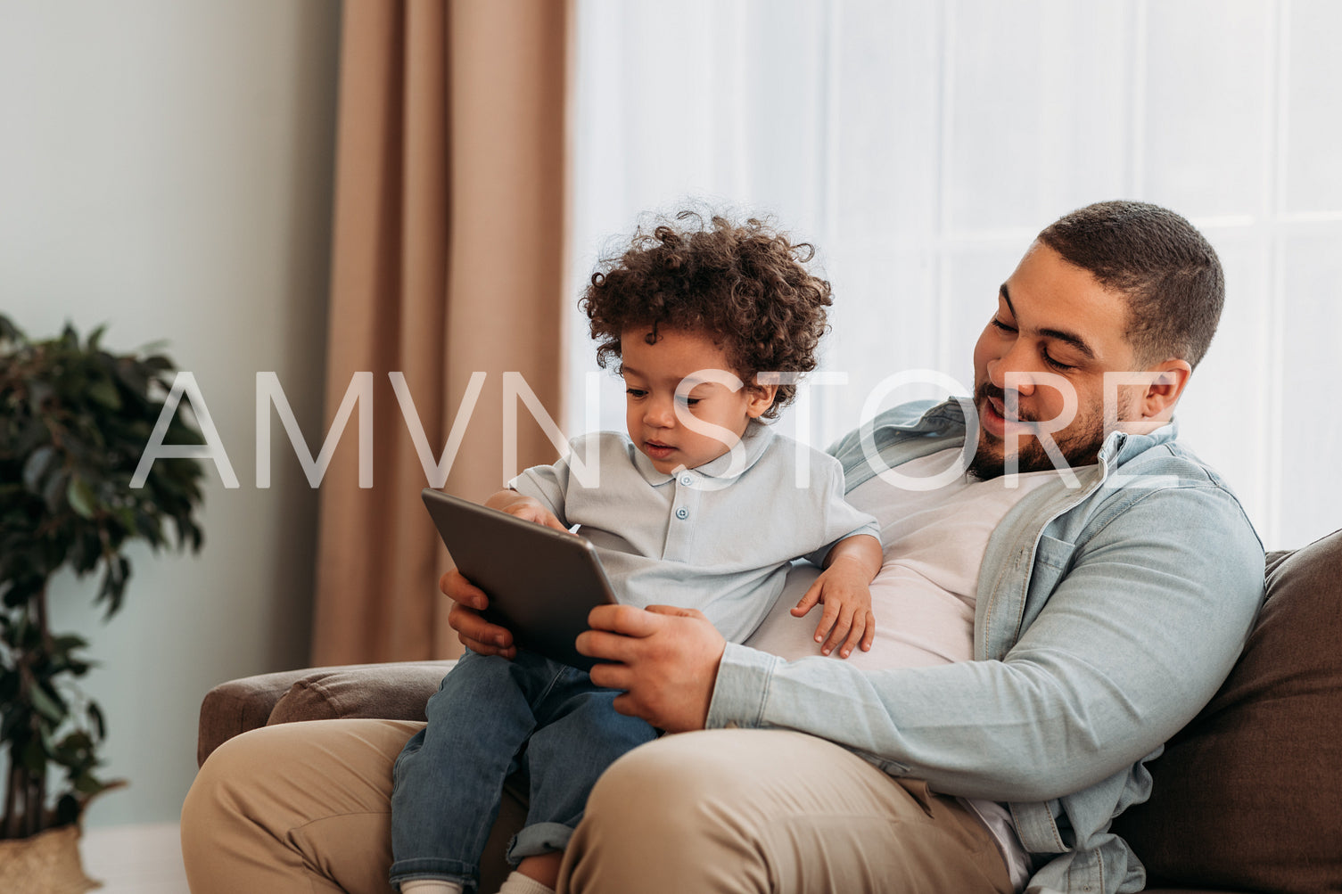 Young father and his little son using digital tablet