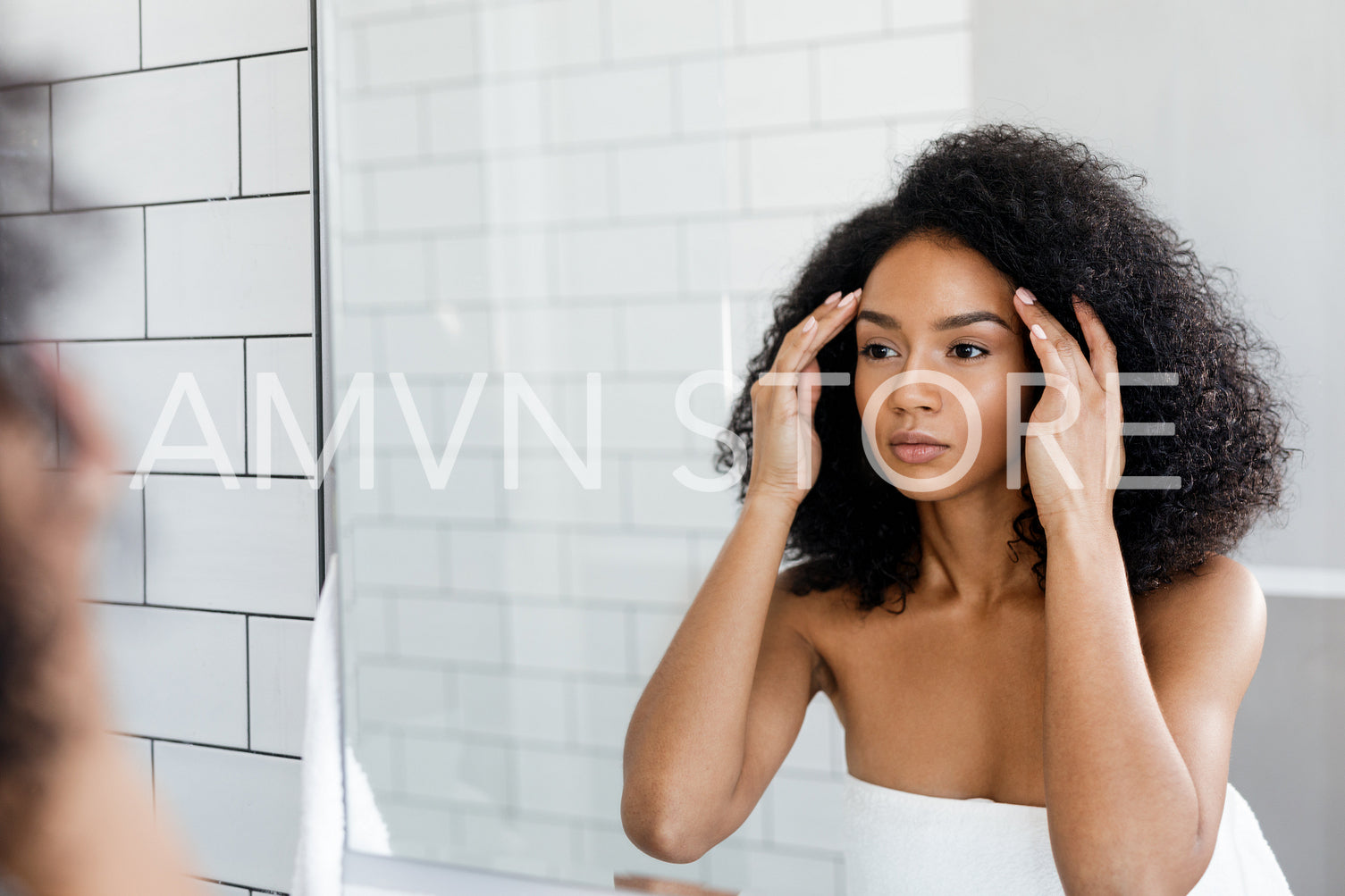 Beautiful woman looking in to mirror, checking her face	