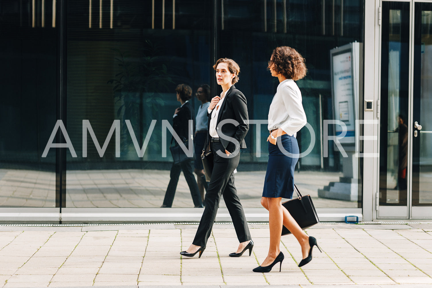 Two women commuting to the office in the day carrying office bags. Ceo and her assistant walking on a city street.	