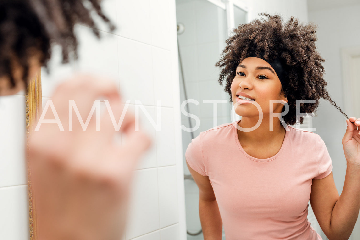 Girl holding up a strand of hair in her bathroom	