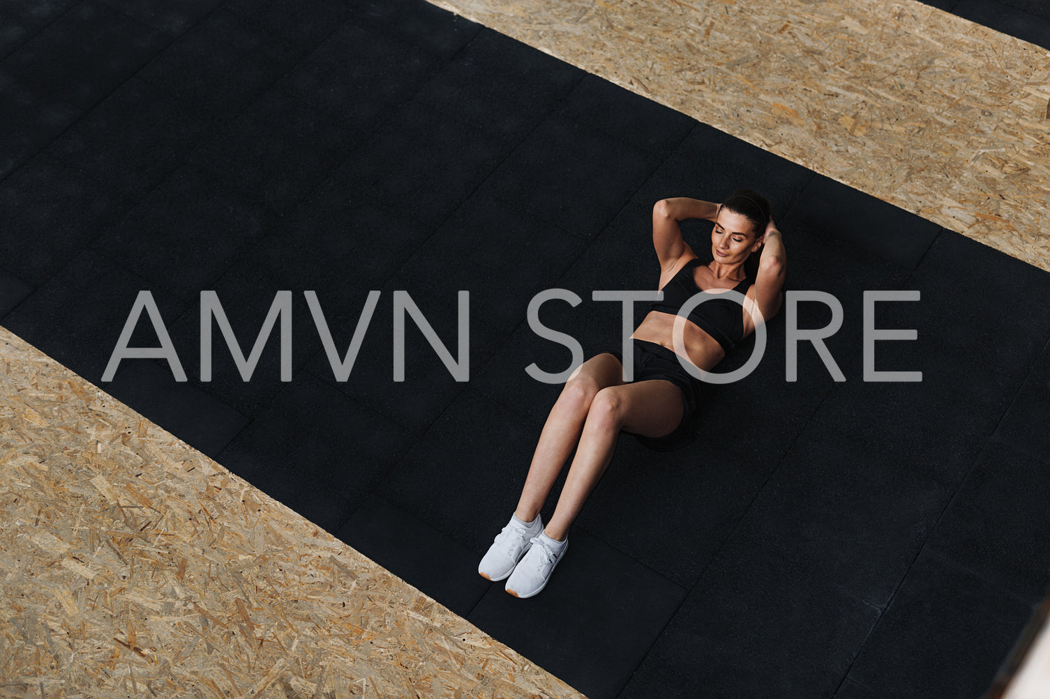 High angle view of young woman doing sit-ups at gym	