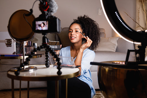 Beauty vlogger applying cosmetics on eyes in home