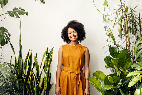 Smiling woman standing at wall in plant shop