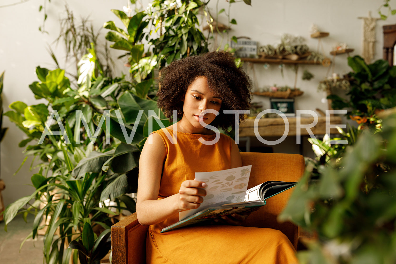 Woman botanist working at her indoor garden sitting on an armchair