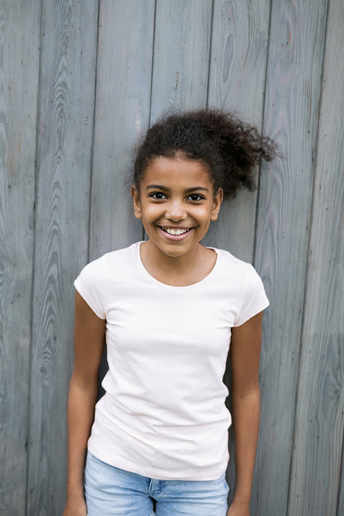 Portrait of a little smiling girl outdoors, looking at camera