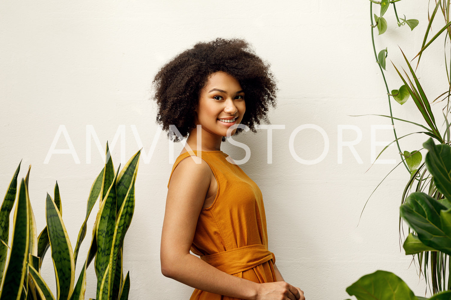 Smiling woman posing at the wall in her botanical studio	