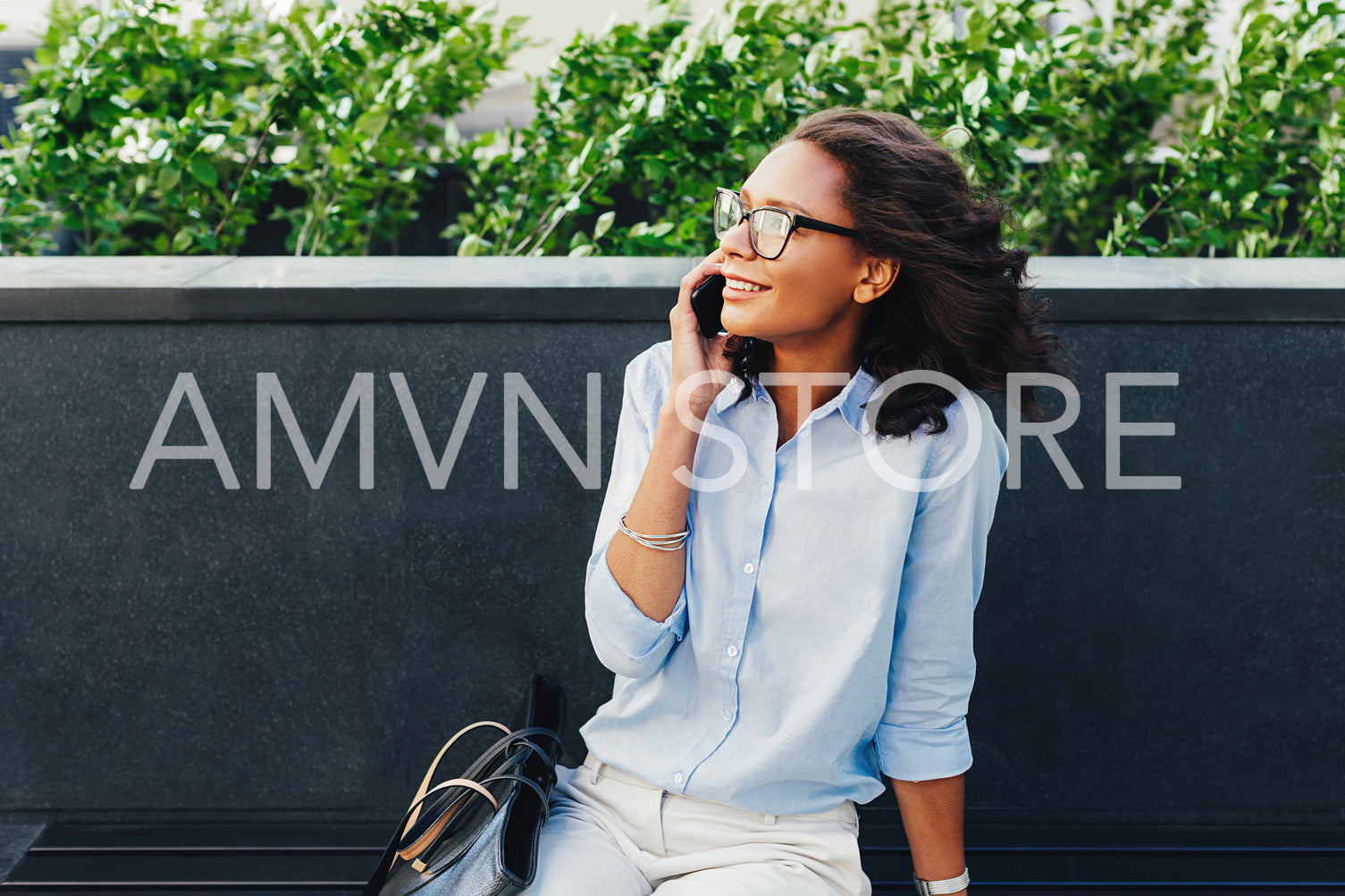 Female entrepreneur sitting outdoors using mobile phone	