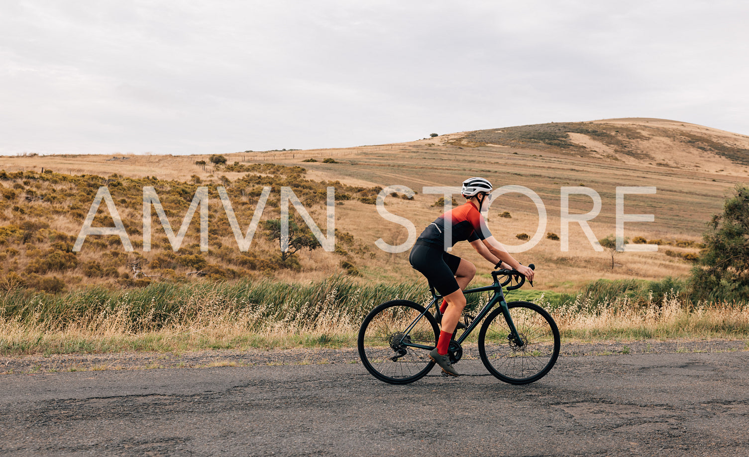 Side view of professional female cyclist in sportswear riding pro bike against beautiful landscape