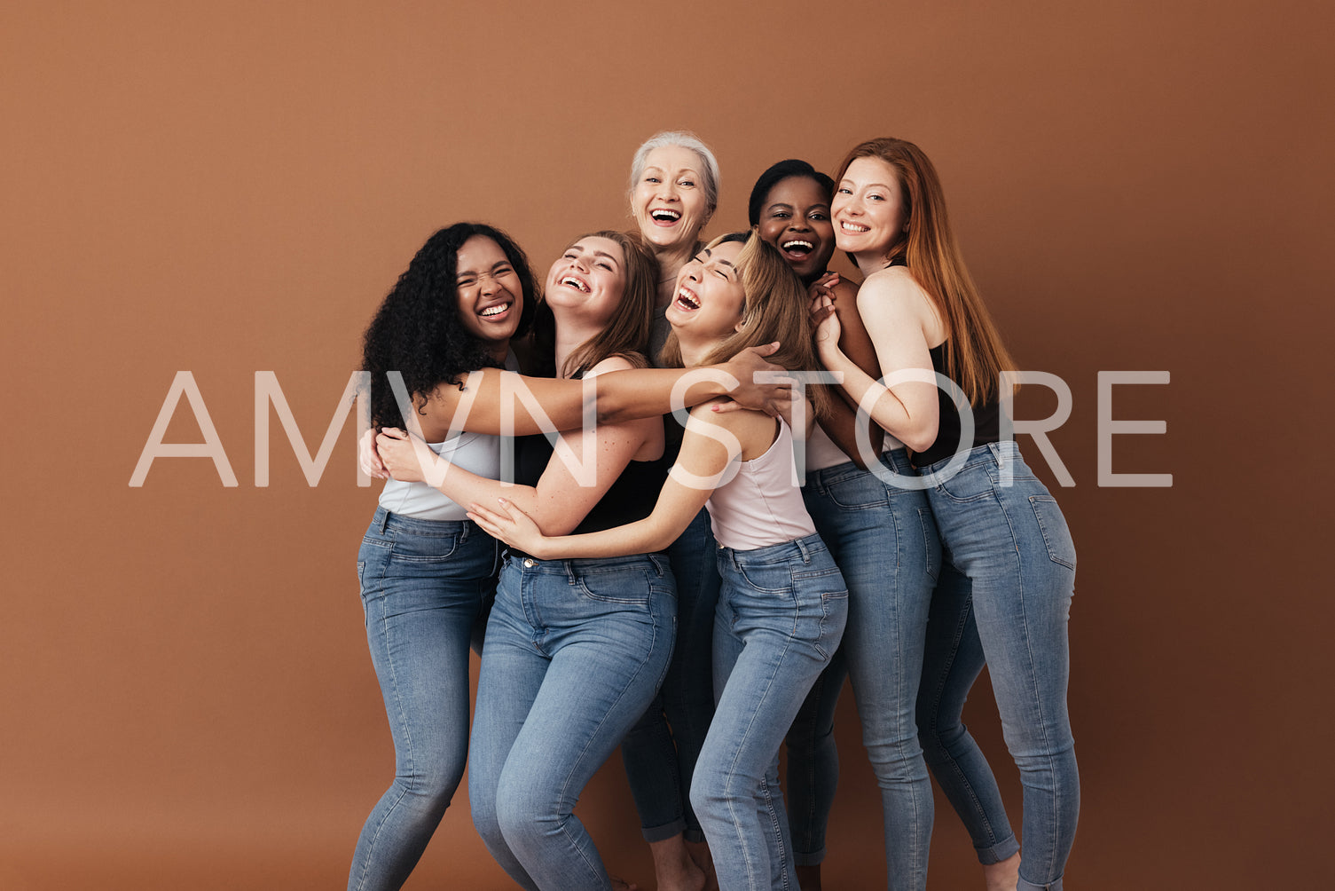 Six laughing women of a different race, age, and figure type. Group of multiracial females having fun against a brown background.