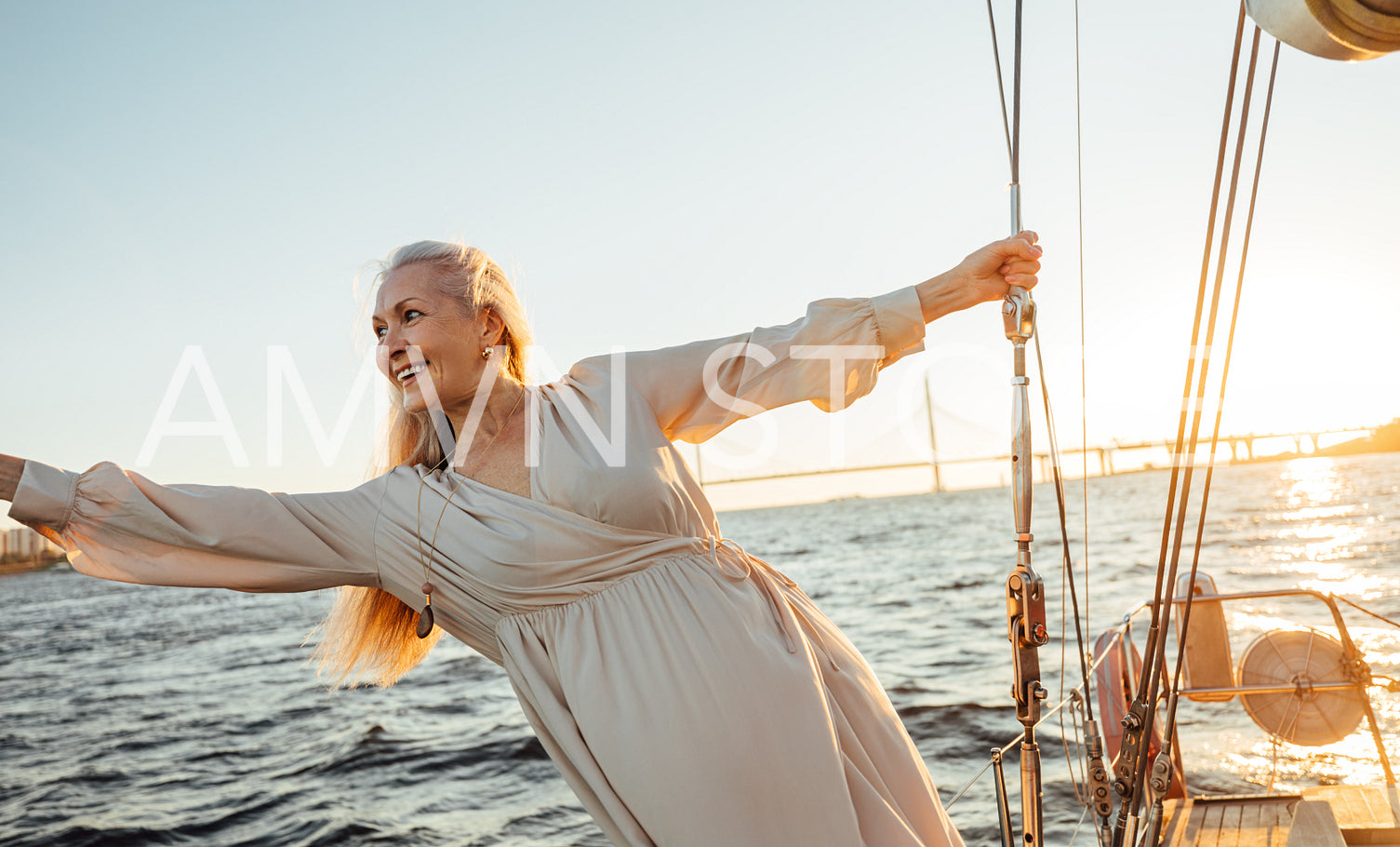 Cheerful mature woman having fun on a private yacht at sunset	