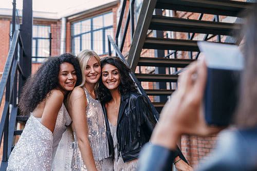 Woman taking photos of her friends outdoors with an instant camera