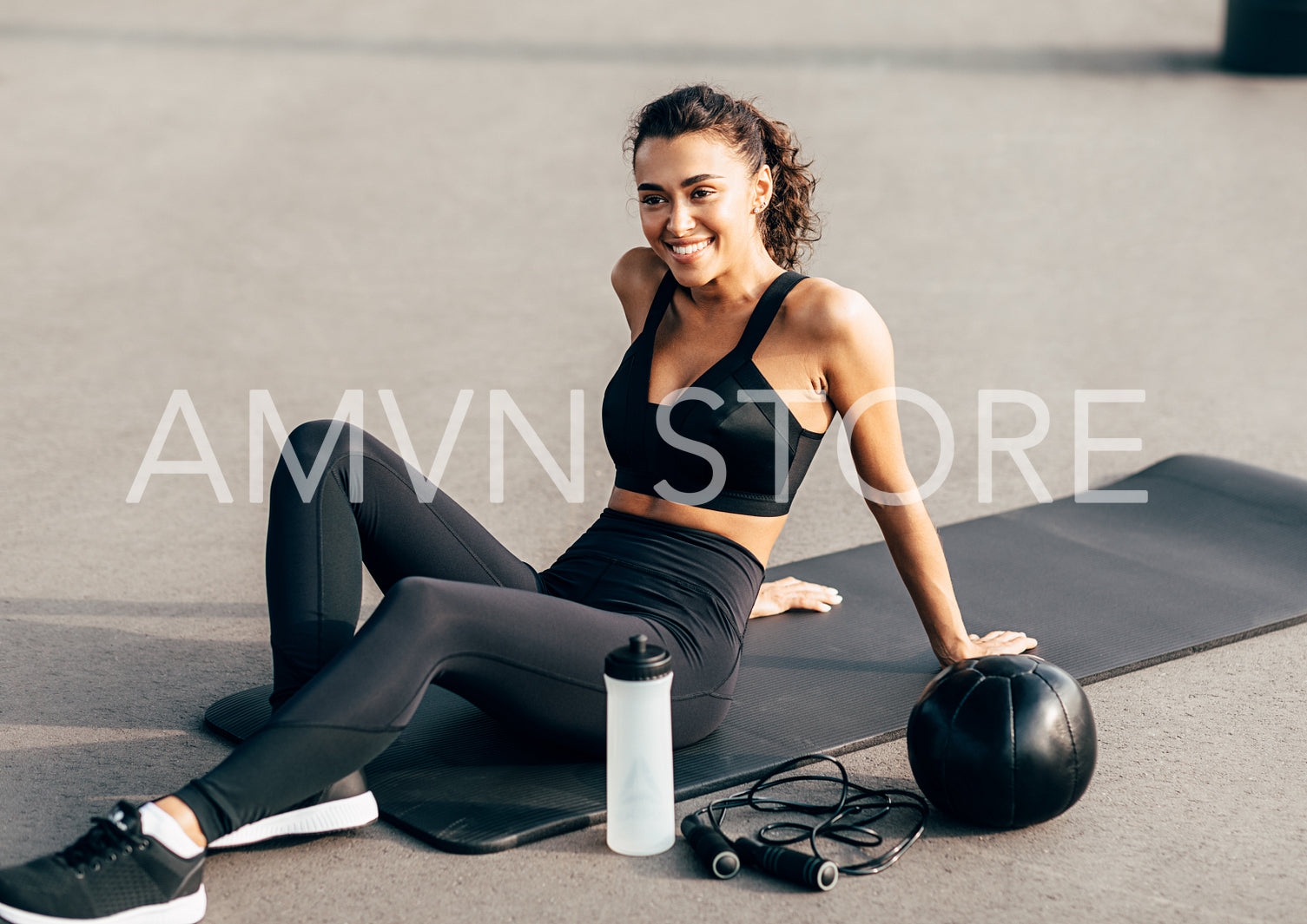 Beautiful sportswoman resting on a mat after exercising outdoors