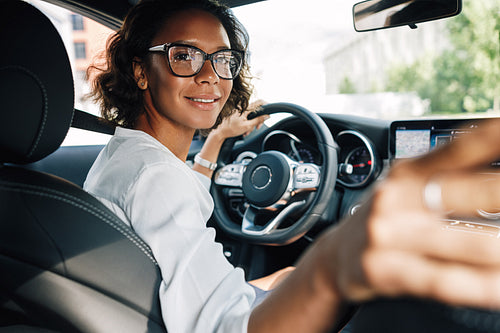 Young smiling woman looking at rear window and parking a car