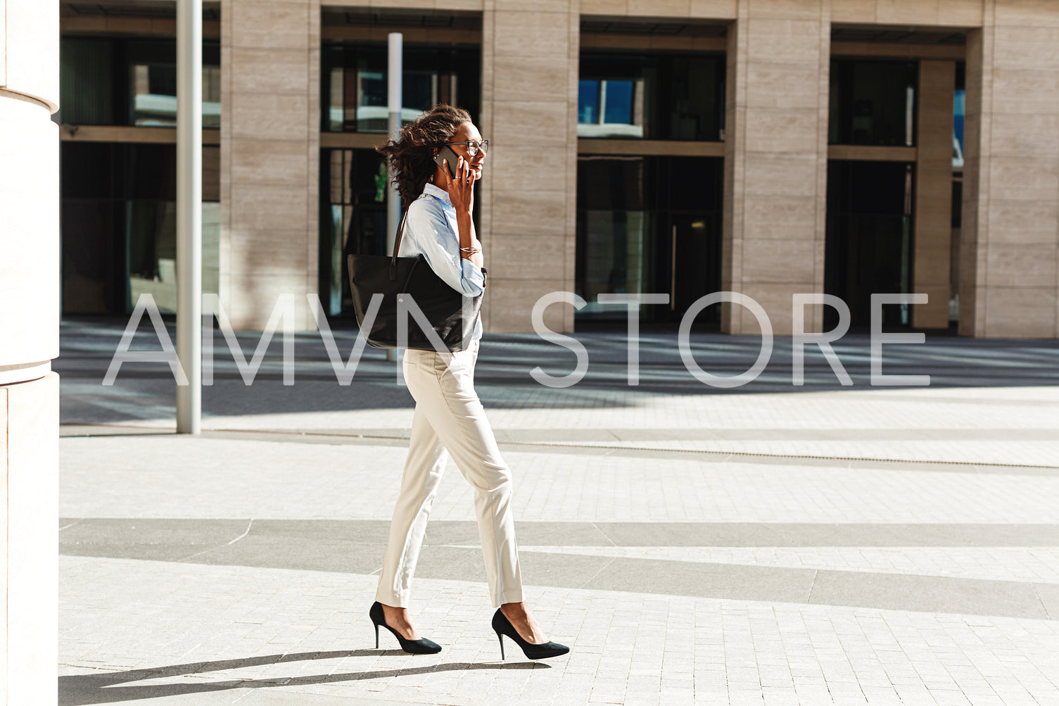 Side view of young businesswoman walking in front of a modern building	