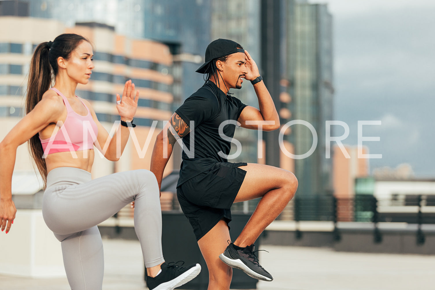 Young athletes are exercising together on rooftop. Man and woman are warming up before training outdoors. 