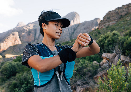 Woman hiker in cap looking at smart watch